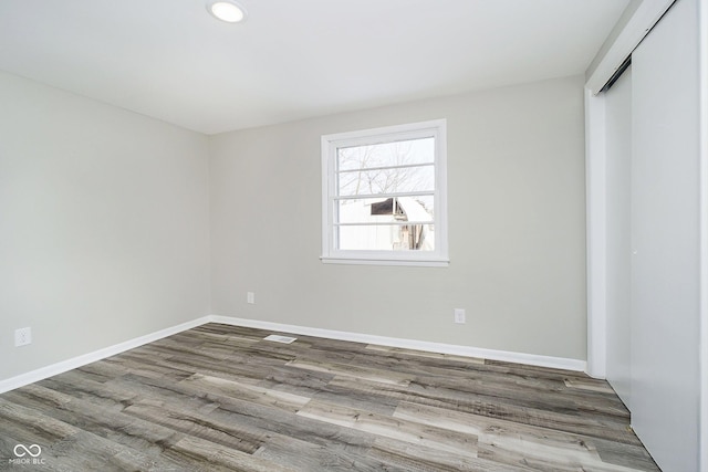 unfurnished bedroom featuring wood-type flooring and a closet