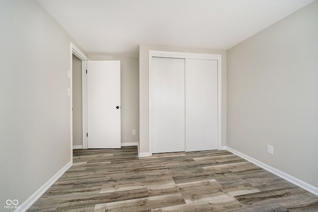 unfurnished bedroom with hardwood / wood-style floors and a closet