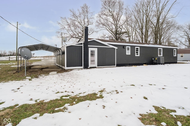 snow covered property with central AC unit