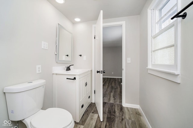 bathroom featuring vanity, wood-type flooring, and toilet