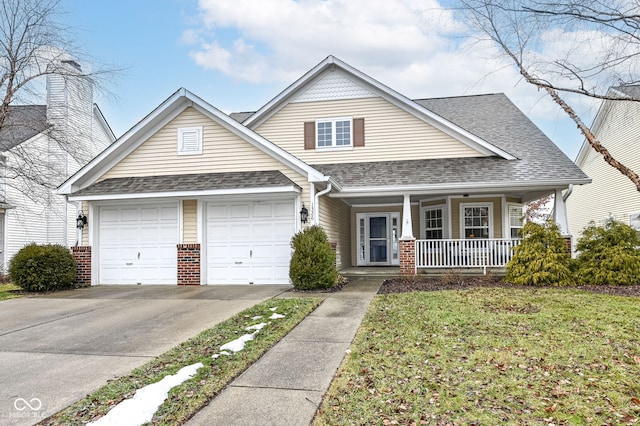 view of front of property with a garage, a front lawn, and covered porch