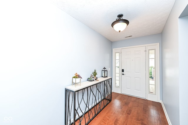 foyer with wood-type flooring and a textured ceiling