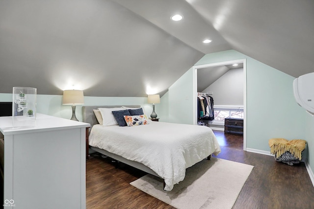 bedroom featuring baseboards, dark wood finished floors, lofted ceiling, a walk in closet, and recessed lighting