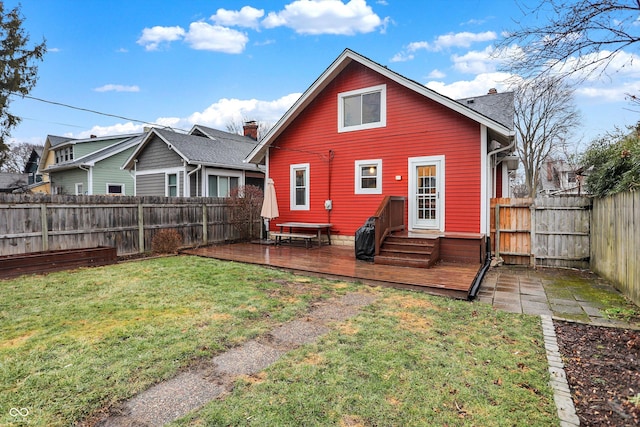 rear view of property featuring a fenced backyard, a wooden deck, and a yard