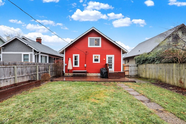 back of house with a fenced backyard, a lawn, and a wooden deck