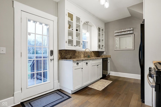 kitchen with glass insert cabinets, white cabinets, a sink, and black appliances