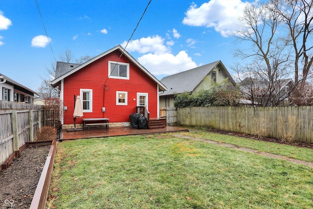 rear view of house featuring a fenced backyard, a deck, and a yard