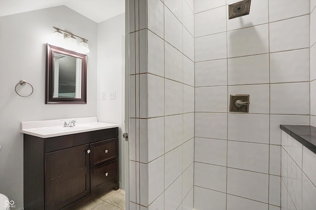 bathroom with tiled shower and vanity