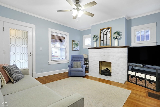 living room with ornamental molding, baseboards, and wood finished floors