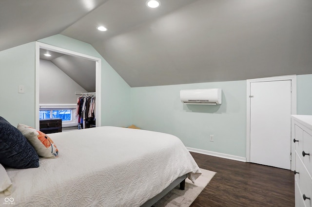 bedroom with dark wood finished floors, lofted ceiling, recessed lighting, an AC wall unit, and baseboards