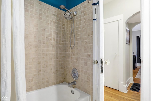 bathroom with wood finished floors and shower / bath combo with shower curtain