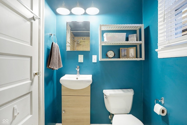 bathroom featuring a shower, vanity, and toilet