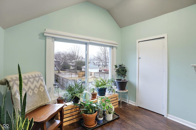 sitting room with lofted ceiling, baseboards, and wood finished floors