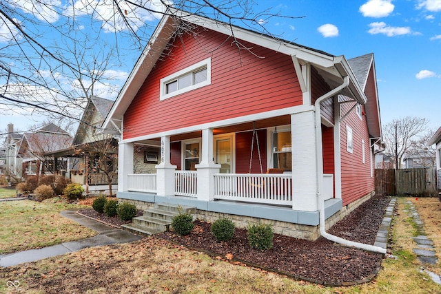 view of front of property with covered porch and fence