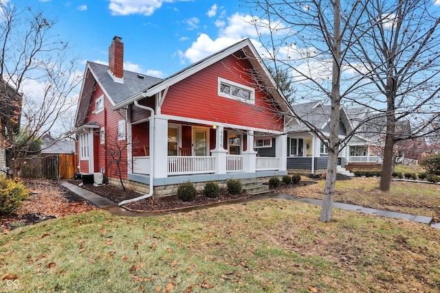 view of front facade featuring covered porch and a front lawn