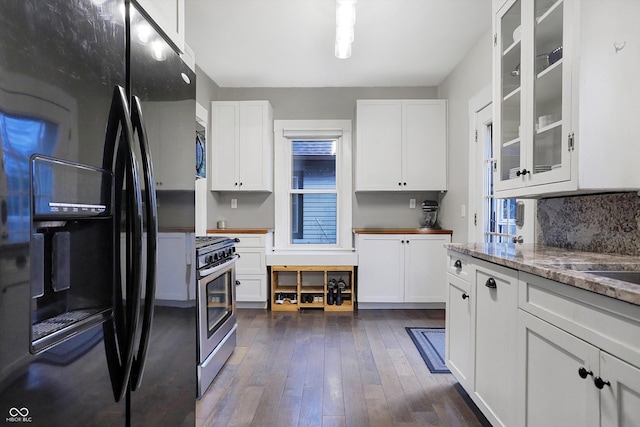 kitchen with dark wood-style flooring, tasteful backsplash, glass insert cabinets, white cabinetry, and black appliances