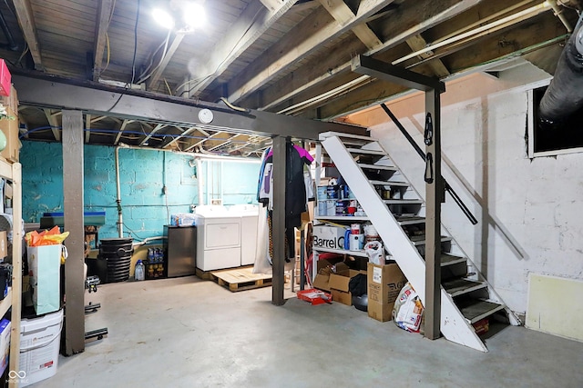 unfinished below grade area featuring stairs and separate washer and dryer