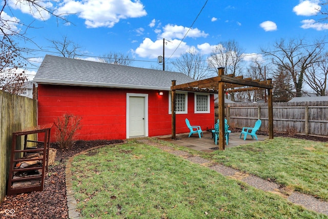 back of property with a fenced backyard, a patio, a pergola, and roof with shingles