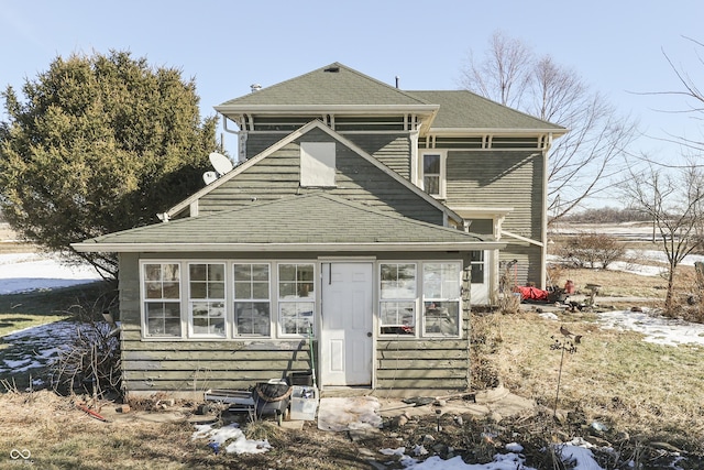 back of property with a sunroom