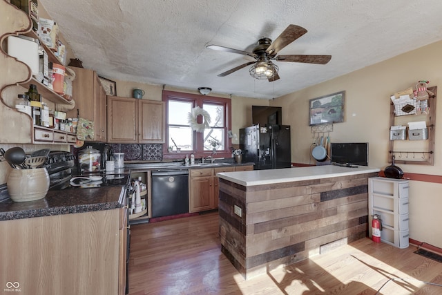 kitchen featuring sink, light wood-type flooring, ceiling fan, black appliances, and a textured ceiling