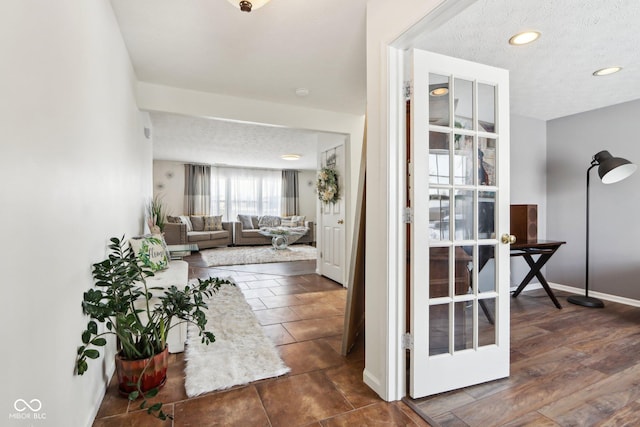 interior space with baseboards, dark wood-type flooring, a textured ceiling, and recessed lighting