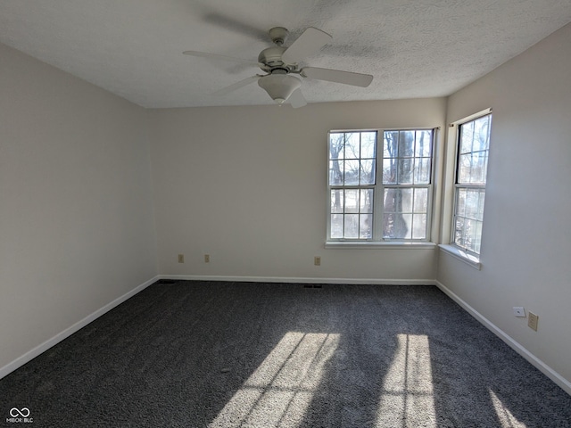 carpeted spare room featuring ceiling fan and a textured ceiling