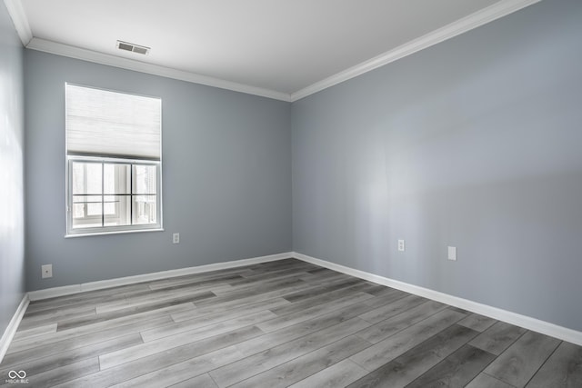 empty room featuring crown molding and light wood-type flooring