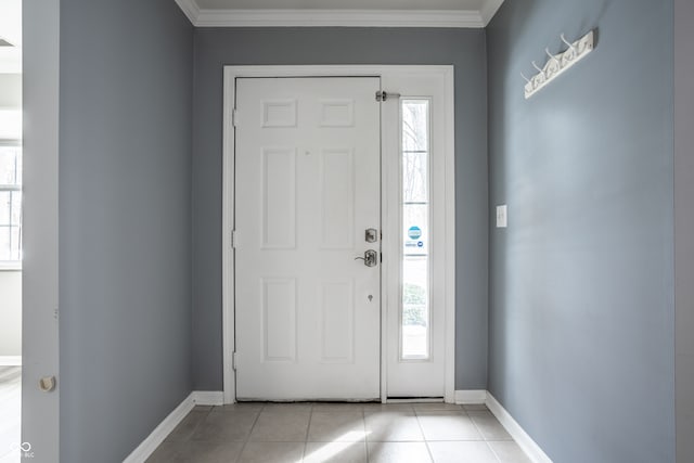 entryway with crown molding and light tile patterned floors