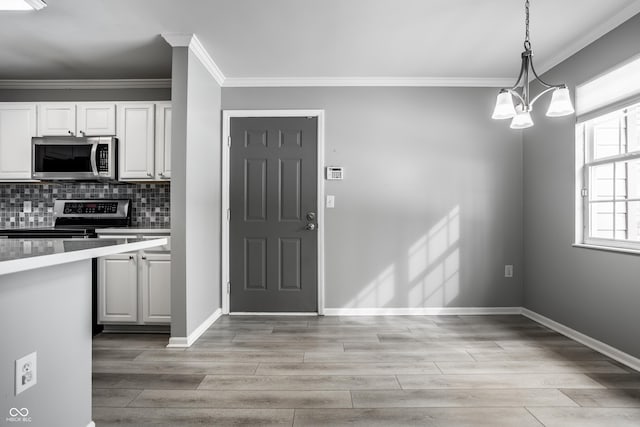 kitchen with white cabinetry, pendant lighting, light hardwood / wood-style floors, and appliances with stainless steel finishes