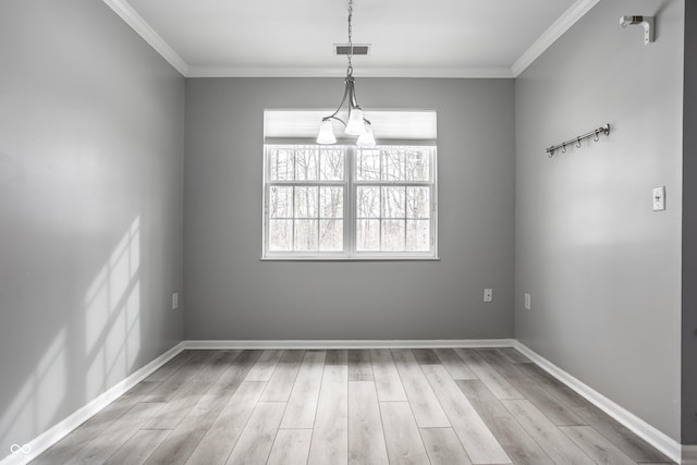 unfurnished dining area with crown molding and light wood-type flooring