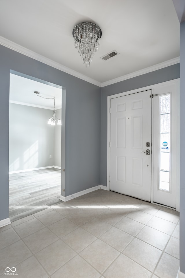 foyer featuring crown molding, light tile patterned flooring, and a notable chandelier