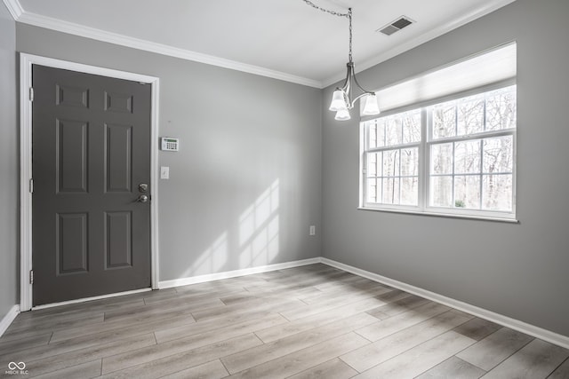 foyer featuring ornamental molding, a chandelier, and light wood-type flooring