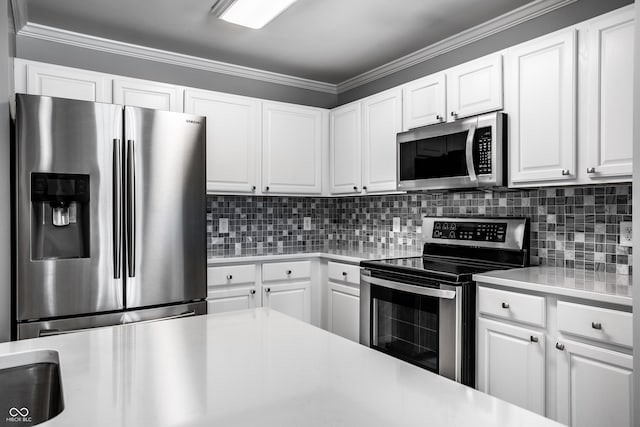 kitchen with backsplash, crown molding, white cabinets, and appliances with stainless steel finishes