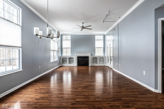 unfurnished living room featuring dark hardwood / wood-style flooring, ceiling fan with notable chandelier, track lighting, and ornamental molding