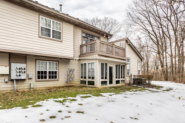 snow covered back of property with central AC unit