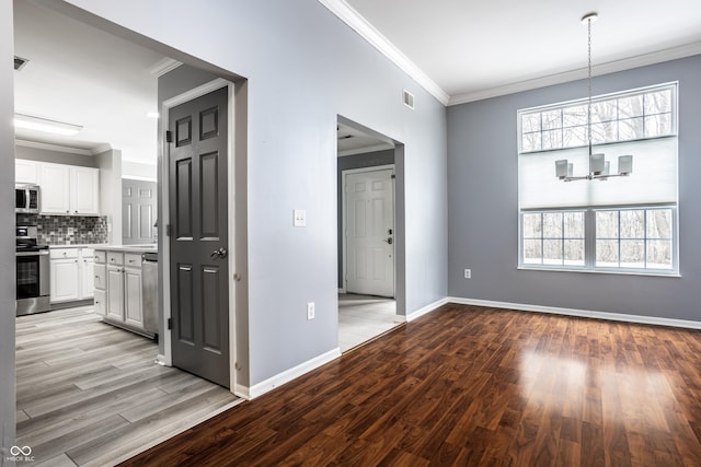 interior space featuring ornamental molding, a chandelier, and light wood-type flooring