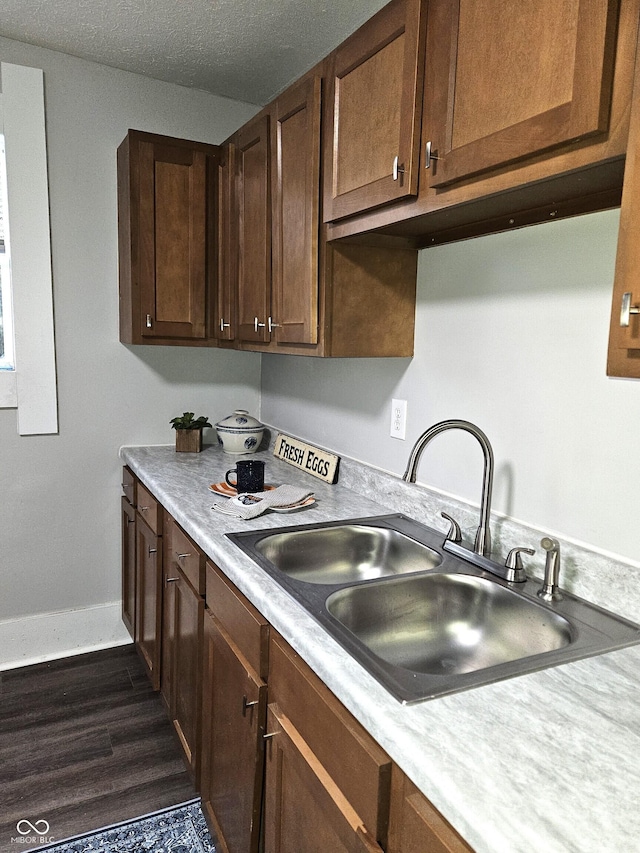 kitchen featuring sink, dark hardwood / wood-style floors, and a textured ceiling