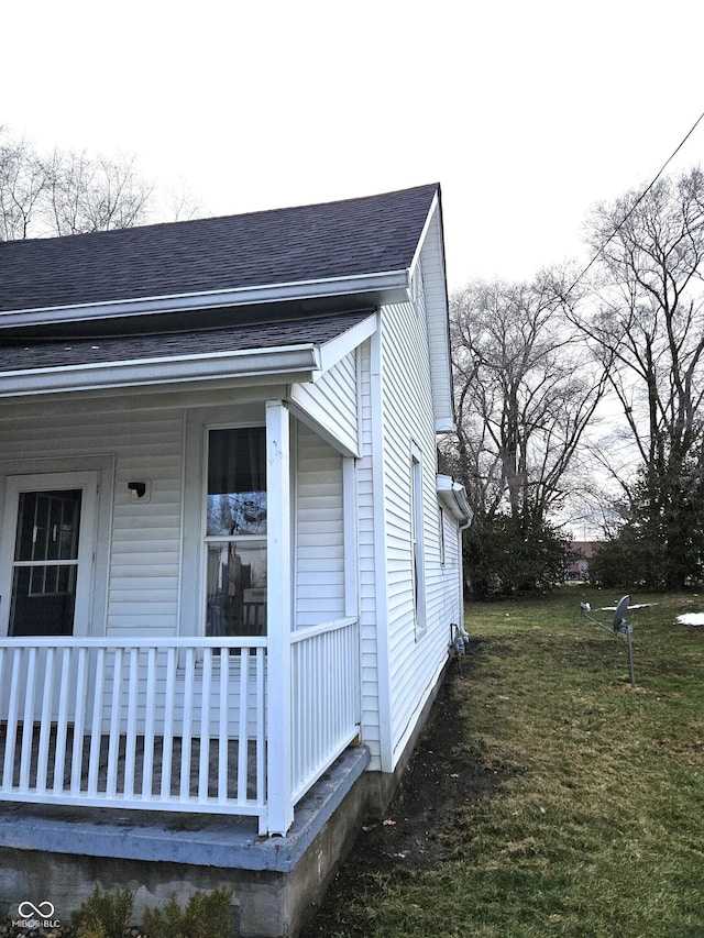 view of side of property featuring a yard and covered porch