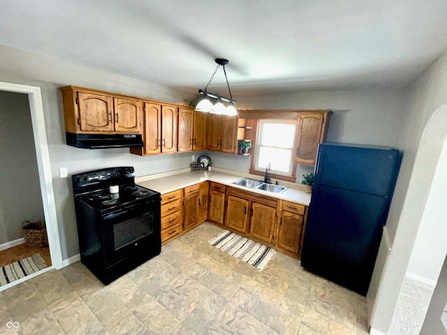 kitchen featuring decorative light fixtures, sink, and black appliances