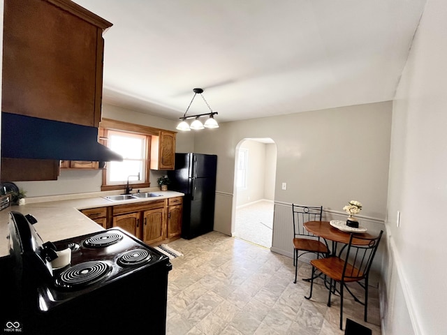 kitchen featuring hanging light fixtures, sink, and black appliances