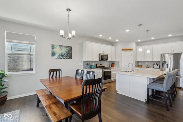 dining room featuring an inviting chandelier, dark hardwood / wood-style floors, and sink