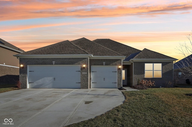 view of front of home with a garage and a lawn