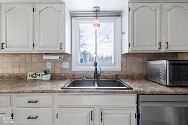 956 Dorchester Dr, Noblesville, IN 46062 - kitchen featuring appliances with stainless steel finishes, a sink, white cabinetry, and decorative backsplash
