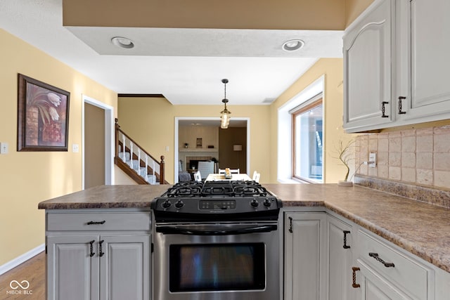 956 Dorchester Dr, Noblesville, IN 46062 - kitchen with gas stove, a peninsula, tasteful backsplash, wood finished floors, and white cabinets