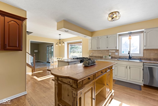 956 Dorchester Dr, Noblesville, IN 46062 - kitchen with dishwasher, a sink, decorative backsplash, and light wood finished floors