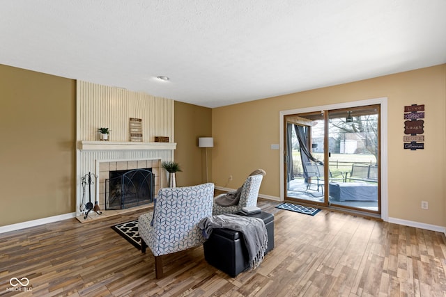 956 Dorchester Dr, Noblesville, IN 46062 - living area with wood finished floors, a tile fireplace, and baseboards