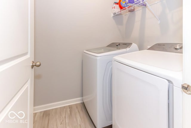 washroom with independent washer and dryer and light hardwood / wood-style floors