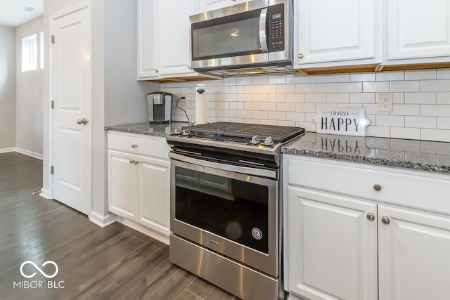 kitchen featuring white cabinetry, appliances with stainless steel finishes, and dark stone countertops