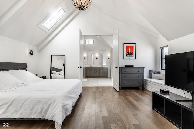 bedroom featuring wood-type flooring, high vaulted ceiling, and ensuite bathroom