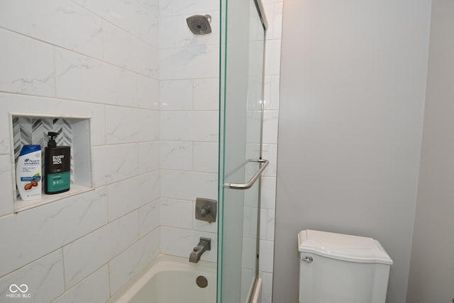 bathroom with toilet and tiled shower / bath